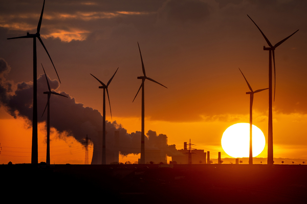 A coal-fired power plant operates near wind turbines in Niederaussem, Germany.