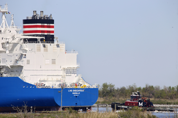 A tugboat helps guide a ship.