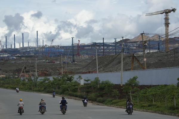 Motorists ride past Indonesia Weda Bay Industrial Park's compound in Central Halmahera, North Maluku, Indonesia, Saturday, June 8, 2024. Indonesia has been building out a vast industry for nickel. 