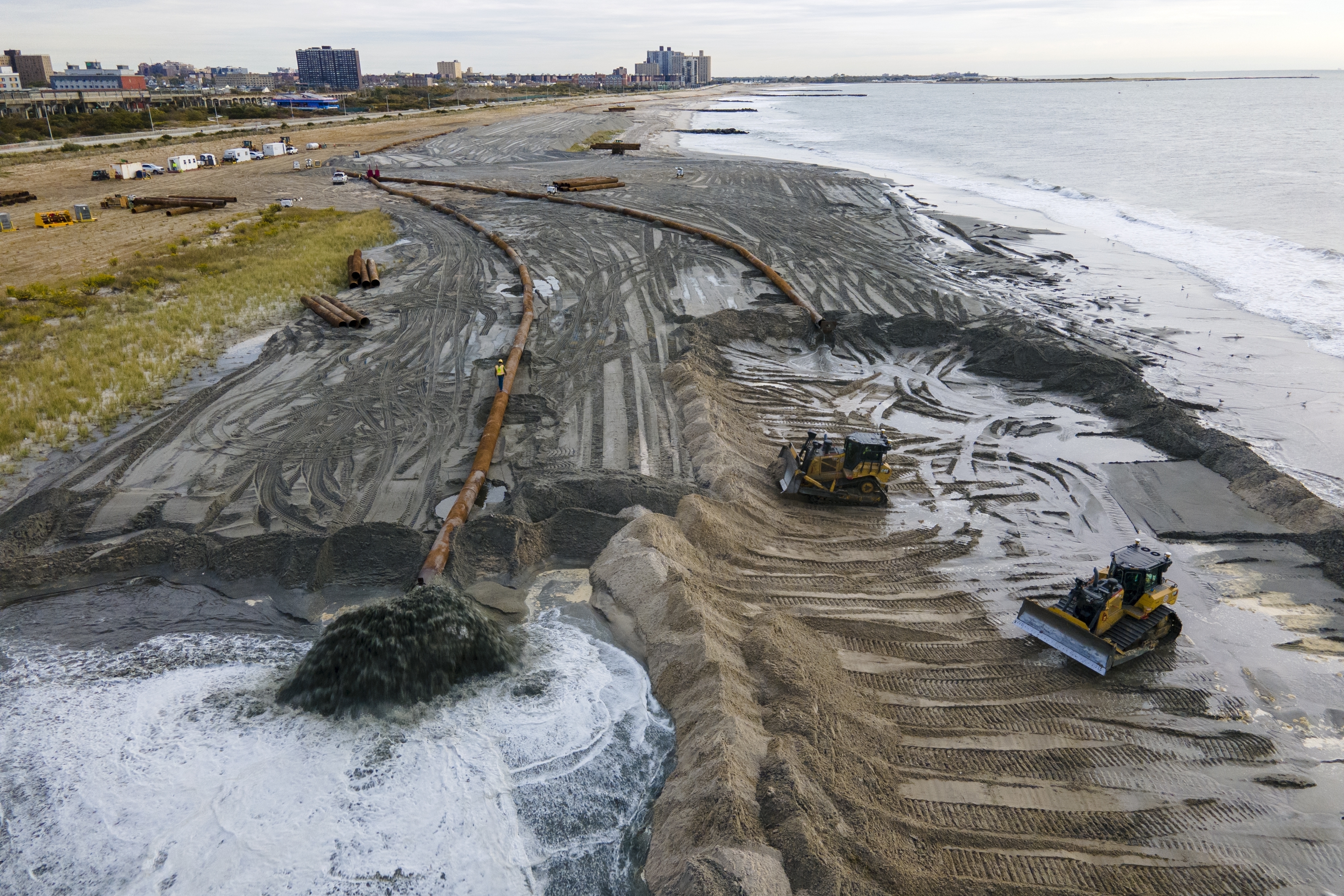 Tractors spread sand on a beach in New York. 