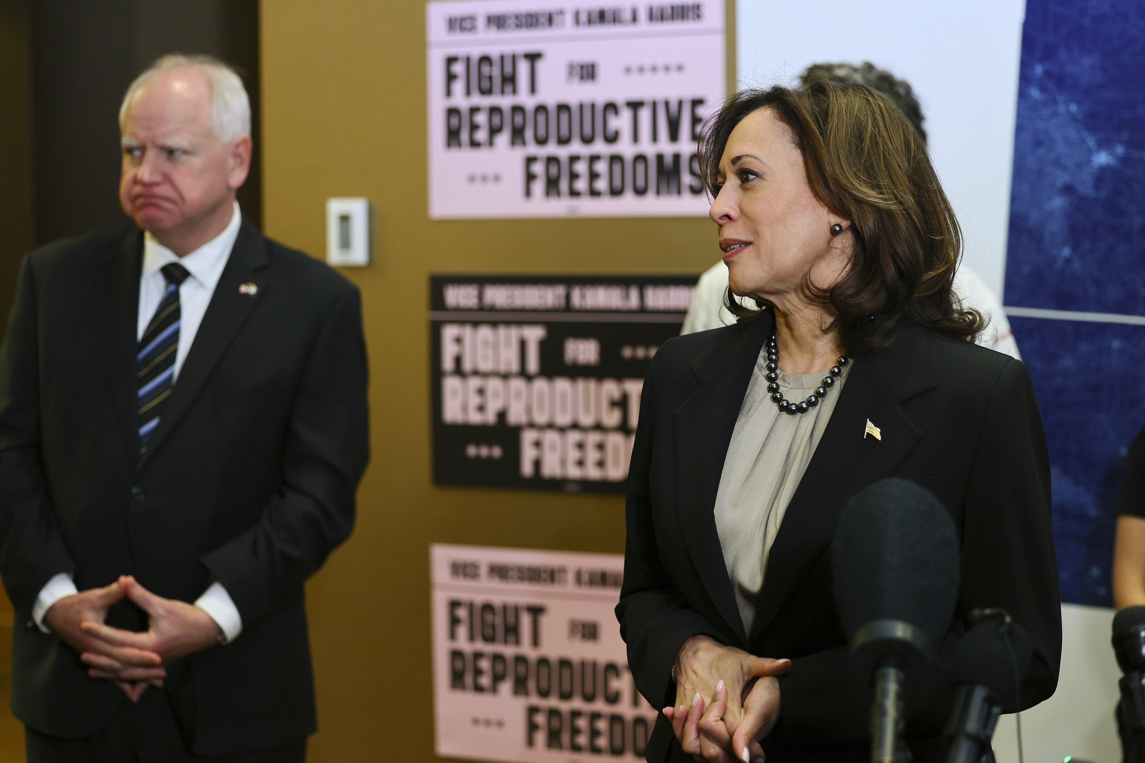 Minnesota Governor Tim Walz (D) listens to Vice President Kamala Harris on March 14, 2024, in St. Paul, Minn