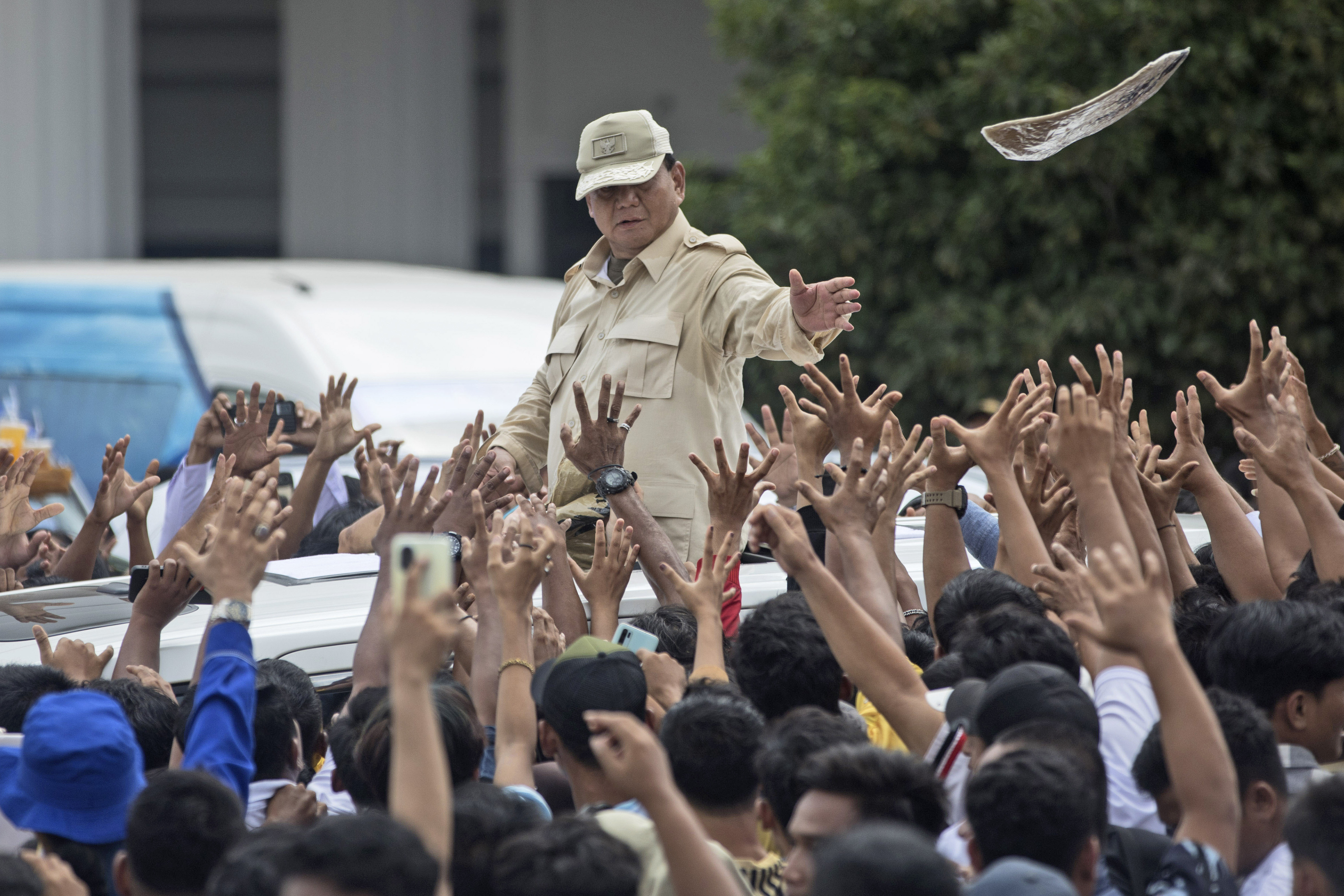 Indonesian presidential candidate Prabowo Subianto tosses a T-shirt.